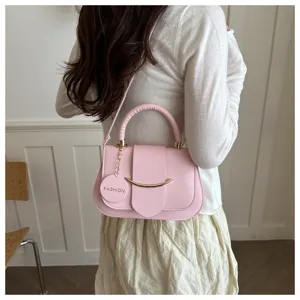 Gedetailleerd overzicht van stijlvolle roze retro dameshandtas met metalen handvat en flap.