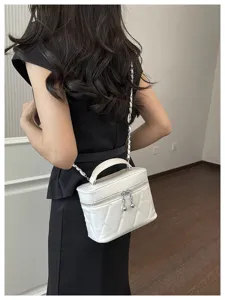 Vue détaillée d'un élégant sac vanity matelassé blanc porté en bandoulière par un modèle.