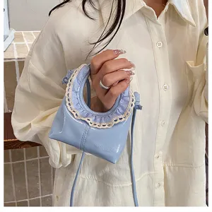 Mini light blue patent leather crescent crossbody bag with cute lace ruffle handle detail.