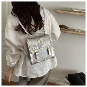 Detail shot of silver metallic women backpack with cute lace trim and bow knot design.