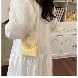 Detailed view of a trendy mini crescent crossbody bag with delicate lace trim and slender strap.