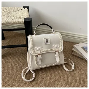 Detailed view of a sweet white mini backpack featuring delicate lace ruffles and cute bear.