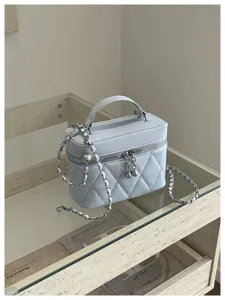 Sac de toilette matelassé bleu clair avec bandoulière chaîne, design chic pour les sorties.