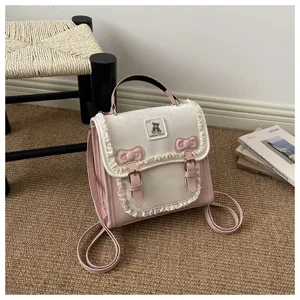 Details of the cute pink and white mini backpack with lace trim, bows and a sweet bear patch.