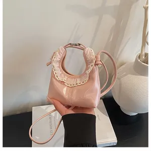 Pink mini crescent crossbody bag detail featuring delicate lace trim and unique aesthetic design.
