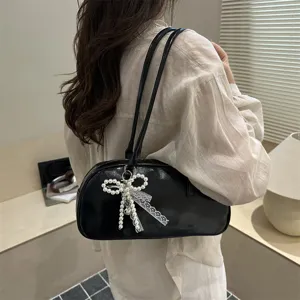 Sac a main noir sous les bras pour femme, elegante trousse de maquillage style minimalist chic.