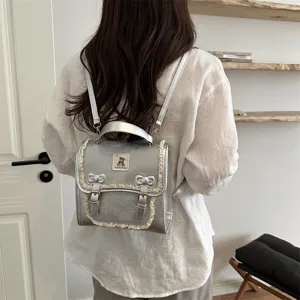 Stylish silver small backpack for women, featuring cute lace trim and bear badge design.