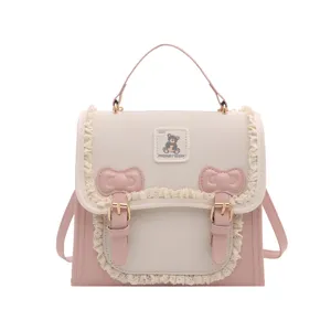 Cute pink and beige mini backpack with sweet lace ruffles, bows, and stylish bear patch.