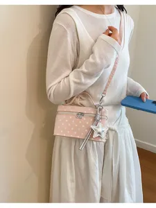 Chic pink polka dot box crossbody bag detail, stylish daily commute handbag with star charm.