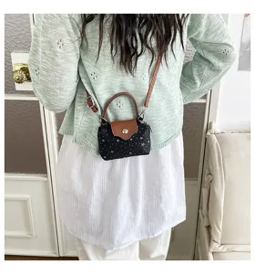 Mini crossbody bag with star pattern, brown leather flap and top handle for women's daily wear.