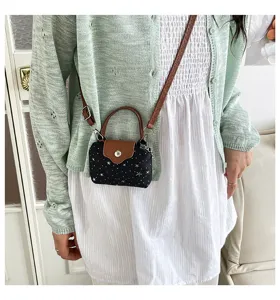 Detailed view of a trendy star-patterned mini crossbody bag with chic brown top handle and strap.