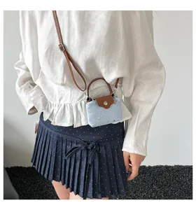 Detail shot of mini star pattern crossbody handbag featuring chic brown leather handles.