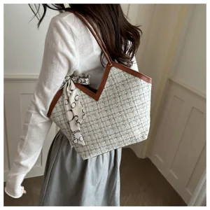 Gedetailleerd overzicht van de tweed shopper met bruine lederen afwerking en sjaal.