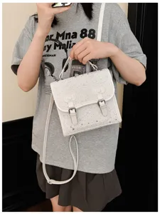 Dettagli della borsa a tracolla bianca elegante con motivi a stelle e doppie fibbie.