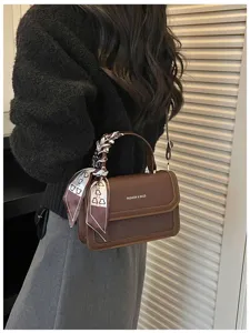 Sac à bandoulière carré rétro marron pour femme, élégant sac à main avec détail de foulard.