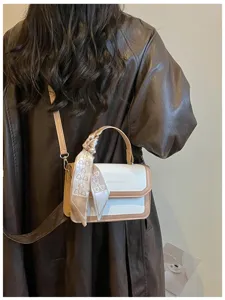 Détail de petit sac carré rétro colorblock avec texture en cuir de qualité et foulard.