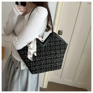 Gedetailleerd overzicht van stijlvolle zwarte tweed tote tas met zijden sjaal.