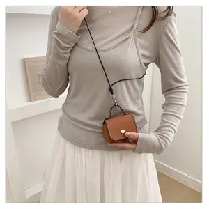Kleine lederen crossbody tas detail, bruine micro schoudertas met riem en metalen slot.