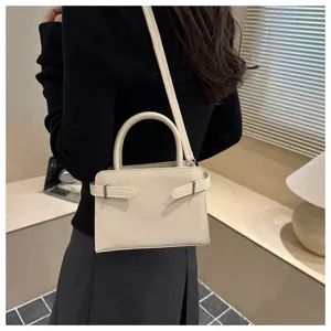 Detailed view of white minimalist shoulder bag with top handle and chic side strap design.