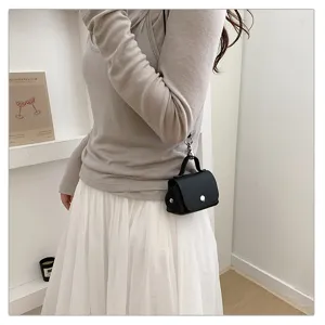 Gedetailleerd overzicht van een chique zwarte gestructureerde mini crossbodytas met slot.