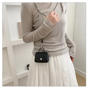 Gedetailleerd shot van trendy zwarte mini crossbody tas van leer, stijlvol gedragen.