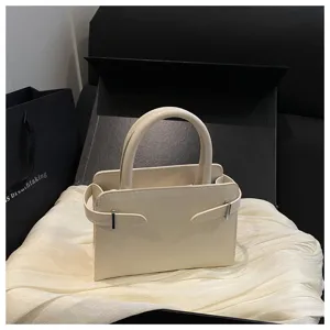 Chic minimalist women top handle small square bag with stylish side strap detail for casual wear.