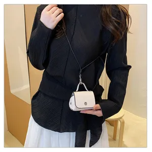 Gedetailleerd overzicht van trendy mini crossbodytas als hanger door model, stijlvol.