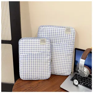 Gedetailleerd overzicht van blauw-witte ruitjes laptophoes met voorvak en ritssluiting.