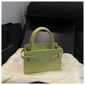 Minimalist light green handbag with top handle and stylish side strap detail for women.