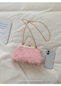 Sac de soirée en résille florale rose avec poignée de perles et bandoulière chaîne.