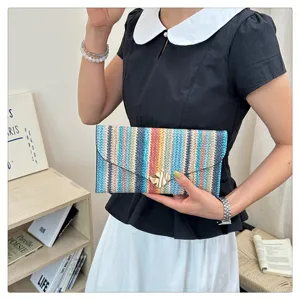 Detailed close-up view of a colorful striped woven envelope clutch bag featuring a sleek metal lock.
