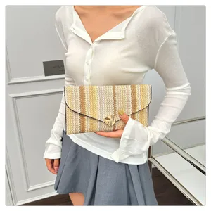 Detailed close-up of colorful striped straw woven envelope clutch bag for summer outfits.