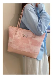 Λεπτομέρεια ροζ τσάντας shopper με λουράκι ώμου, φιόγκο διακόσμηση και συνθετικό δέρμα.