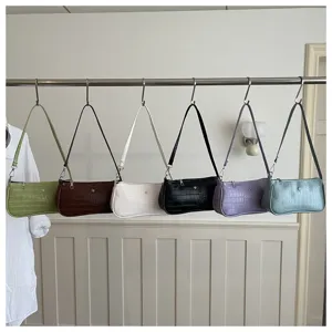 Sac a l'aisselle minimaliste tendance avec texture croco et details metalliques chics.