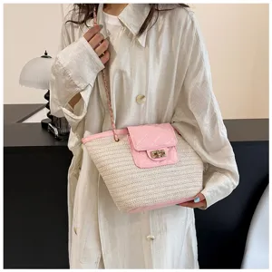 Chique geweven stro schoudertas met ketting en roze gewatteerde flap, elegante zomertas.