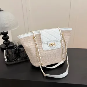 Chique geweven strooien tote tas met gewatteerde lederen flap en gouden ketting voor vakantie.