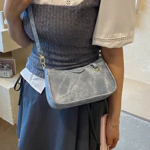 Detailed view of light blue denim shoulder bag with metal hardware and stylish casual design.
