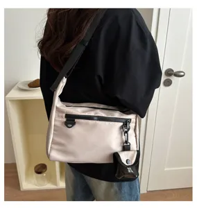 Japanese minimalist messenger bag for women, casual crossbody shoulder bag with front pocket.