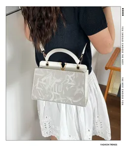 Chic white graffiti shoulder handbag for women, trendy crossbody bag with metal V clasp.