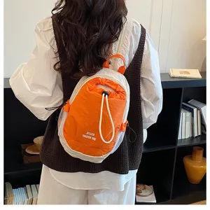 Detailed view of the stylish orange and white color-block backpack, showcasing lifestyle setting.