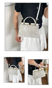 Detailed view showing the elegant white top handle shoulder bag with classic monogram design.