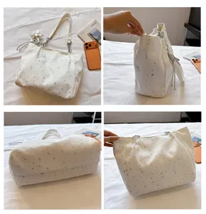 Detailed view of white large capacity tote shoulder bag with silver stars and chain.