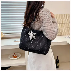 Detailed view of the black star print shoulder tote bag with silver star charm item.