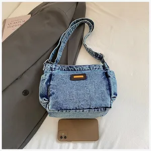 Denim shoulder bag detail showing textured fabric, side pocket, and stylish daily strap.