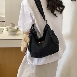 Stylish black canvas shoulder bag casual dumpling crossbody bag with cute plush bear pendant.