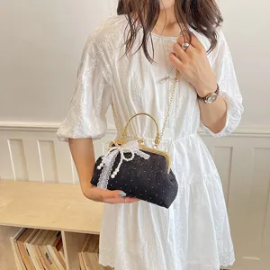 Chic black vintage kiss-lock handbag with pearl lace bow, gold handle and chain strap.