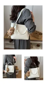 Details of white bucket shoulder bag with cute bear charm for women daily fashion use.