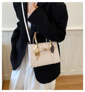Detailed view of women's retro handbag with scarf accent and chic shoulder strap.