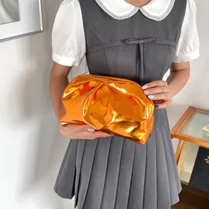 Detailansicht der stilvollen glänzenden Plissee Clutch Tasche in Orange für Damen Alltag.
