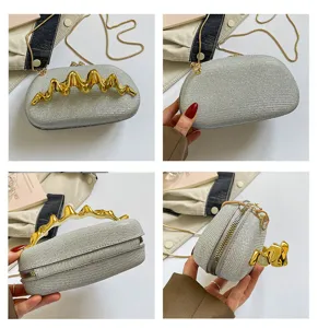 Detailaufnahmen der glitzernden silbernen Damentasche mit goldenem Wellengriff und Kette.